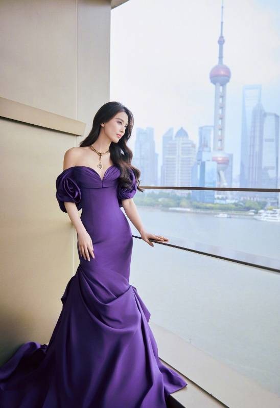 黄圣依欣赏窗外美景，一袭紫色礼裙勾勒出她的曼妙身姿，景美人也美。