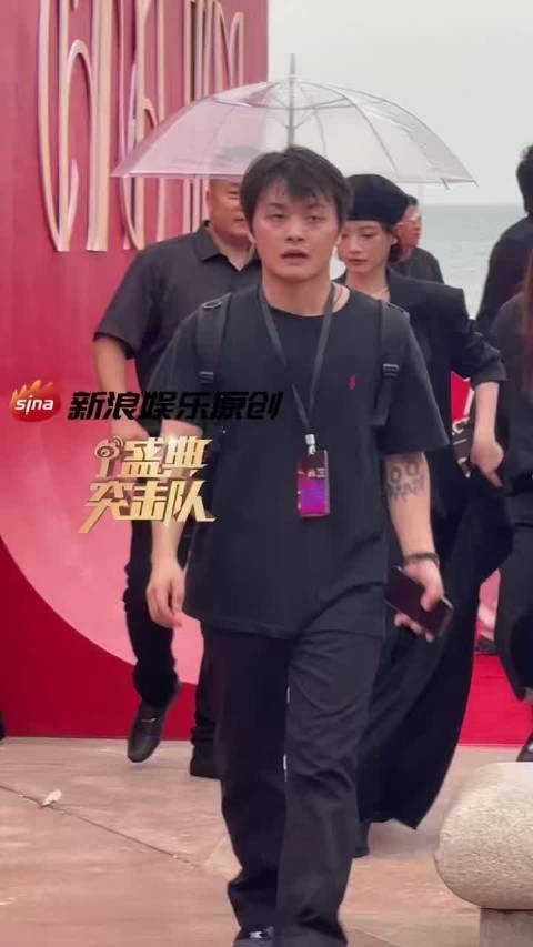 演员李庚希亮相红毯，头戴贝雷帽，身着黑色长裙，微笑点头回应