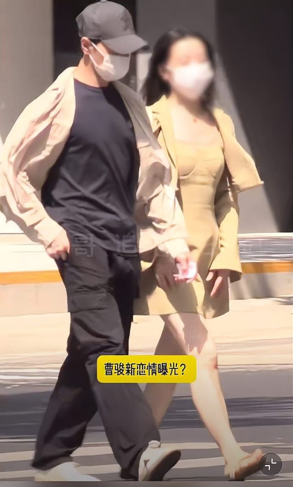 两人佩戴口罩街头行走，图片中有文字“曹骏新恋情曝光？”