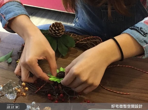 不用急著黏著固定，先在藤圈上決定大致的擺放位置，特別凸顯紅色、綠色的元素，營造出視覺焦點。