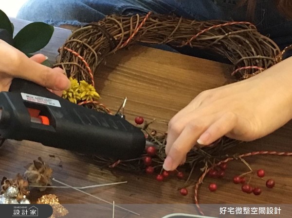 使用熱熔槍固定花材位置，或是選用有附鐵絲的花材，可以直接插入藤圈空隙固定。