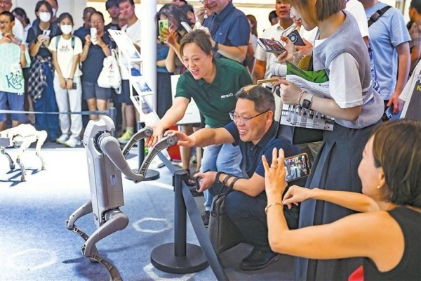 多款智能机器人亮相上海2025世界人工智能大会,成为吸睛焦点。7月29日,参观者和一款机器狗互动。新华社发