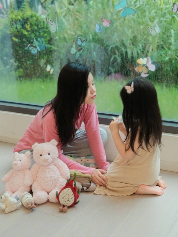 杨子姗对着女儿隔空嘟嘴亲亲。