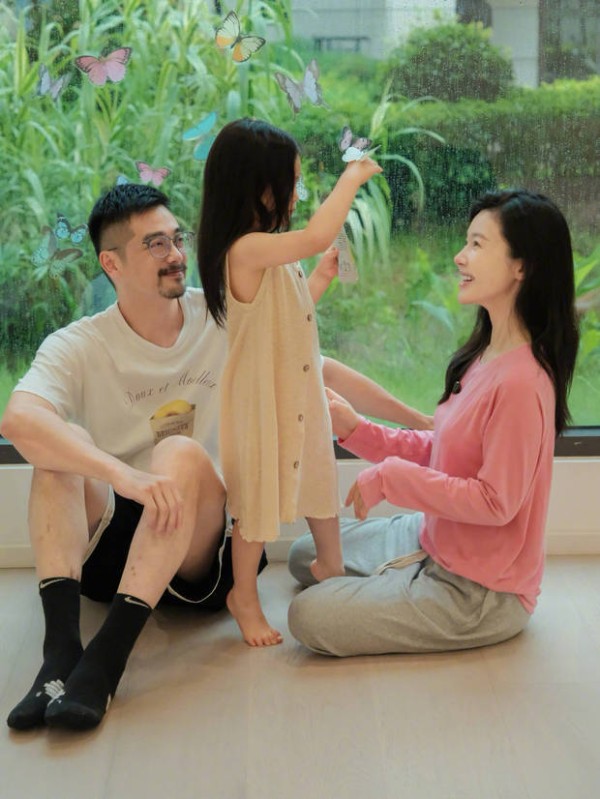杨子姗夫妻俩看着女儿玩耍，面露开心笑容，爱意满满。