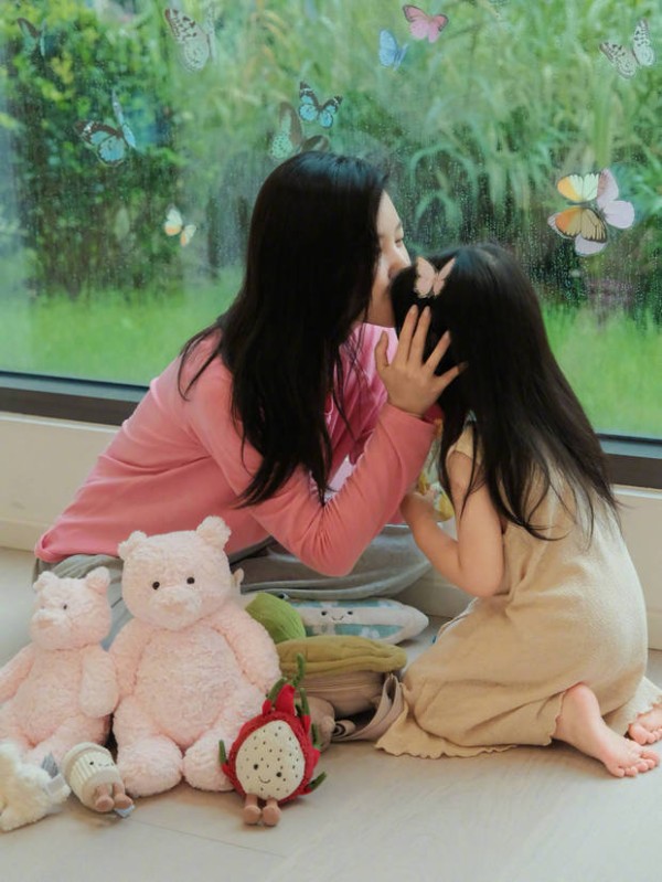 杨子姗亲吻女儿的额头。