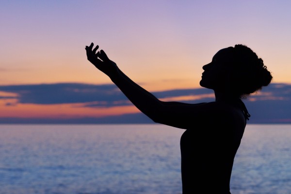 mujer haciendo meditacion en la playa