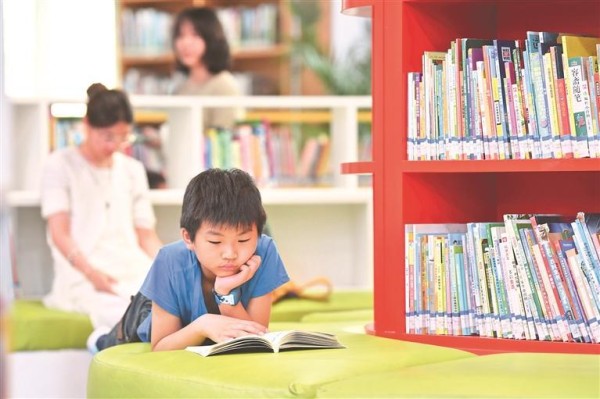 暑假期间，一名小学生正在贵阳市南明区图书馆内阅读图书。赵松 摄