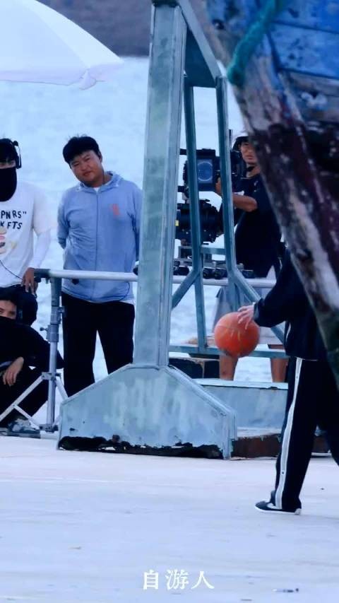 少年海边打篮球引围观，场外观众咧嘴笑