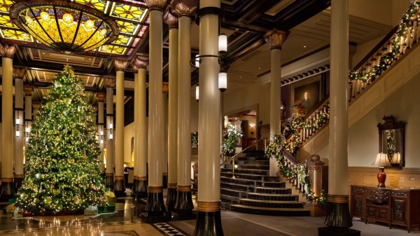 christmas tree in a hotel lobby with staircase and posts