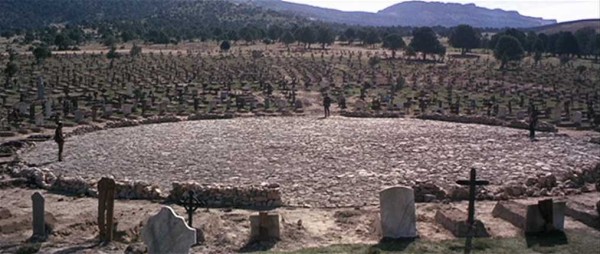 Wide shot of three men in circular graveyard arena