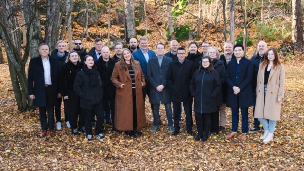 EWQ:n henkilökunta ryhmäkuvassa syksyisessä maisemassa.