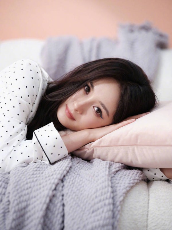 杨幂趴在枕头上，甜美温柔。