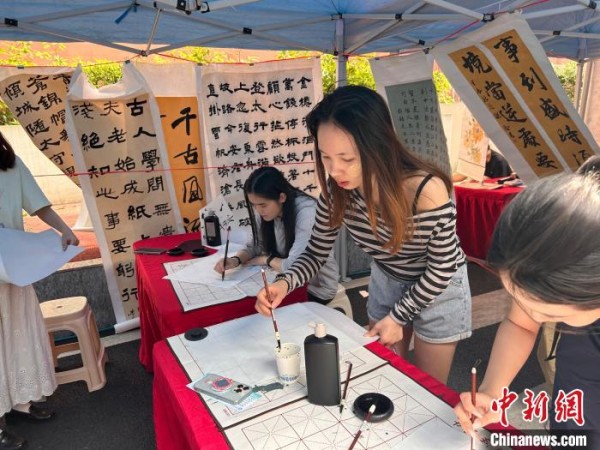 4月16日，广西民族大学举办“多彩五洲韵，合美相思湖”2025年国际文化节。图为学子在写书法。吴昕 摄