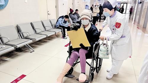 12月9日，在白求恩国际和平医院，白求恩志愿服务队的志愿者帮助腿脚不便患者就医。张彬楠摄