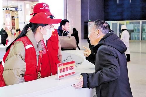 12月7日，在石家庄火车站为民服务台，河北省爱心公益协会的志愿者正在为旅客提供咨询服务。 本报记者赵泽众摄