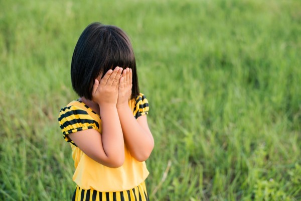 shy girl covering her eyes 
