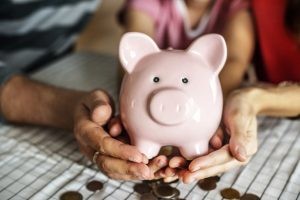 woman and man holding piggy bank with child 