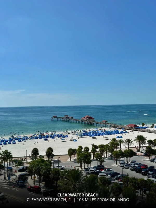 View of Clearwater Beach with white sand and blue umbrellas, one of the closest Gulf beaches to Orlando.