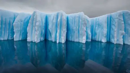L’eau et l’air chaud ont sculpté cet iceberg. “ Tandis que sa base fondait, explique le ...