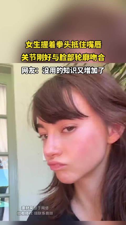 女生握着拳头抵住嘴唇，关节刚好与脸部轮廓吻合