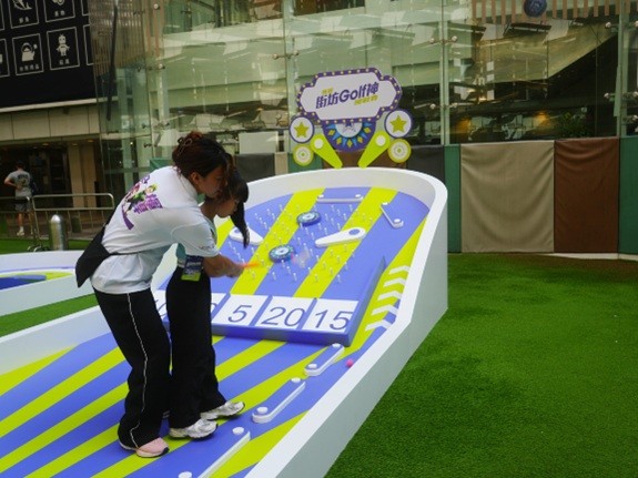 教练在现场细心指导小朋友挥杆技巧，让他们在游戏中学习运动基本功。