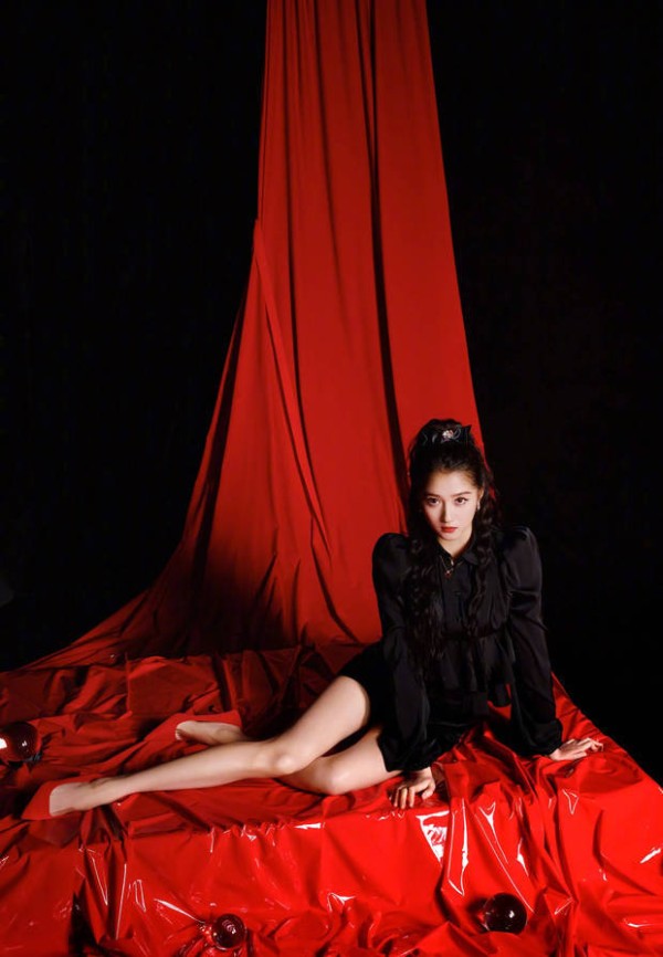 关晓彤坐在红色背景布上,眼神清冷。