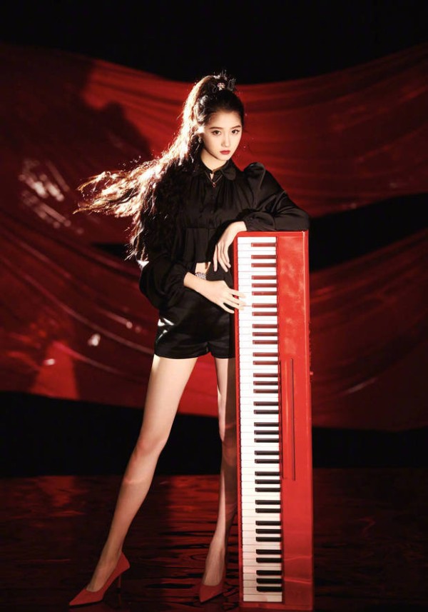 关晓彤倚靠红色钢琴,眼神坚定,尽显飒爽魅力。