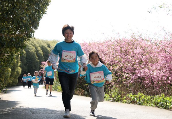 家長攜手孩子奔跑。李齊攝