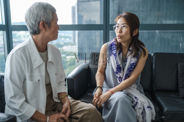 一位资深亚洲商业领袖在现代办公室环境中与一位女商人进行战略对话照片摄影图片