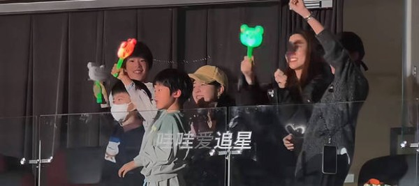 两家人一起挥动应援棒，画面温馨。