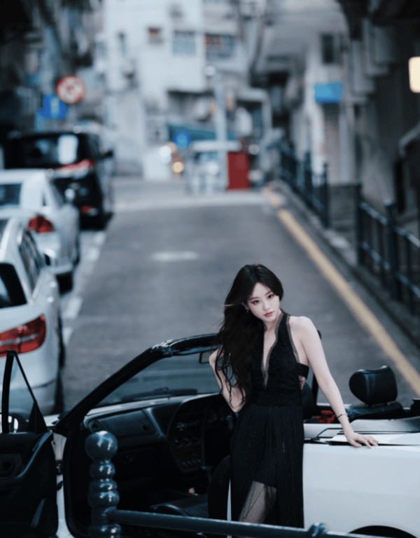 祝绪丹侧身立在车旁,黑色长裙贴衬出纤柔身形。