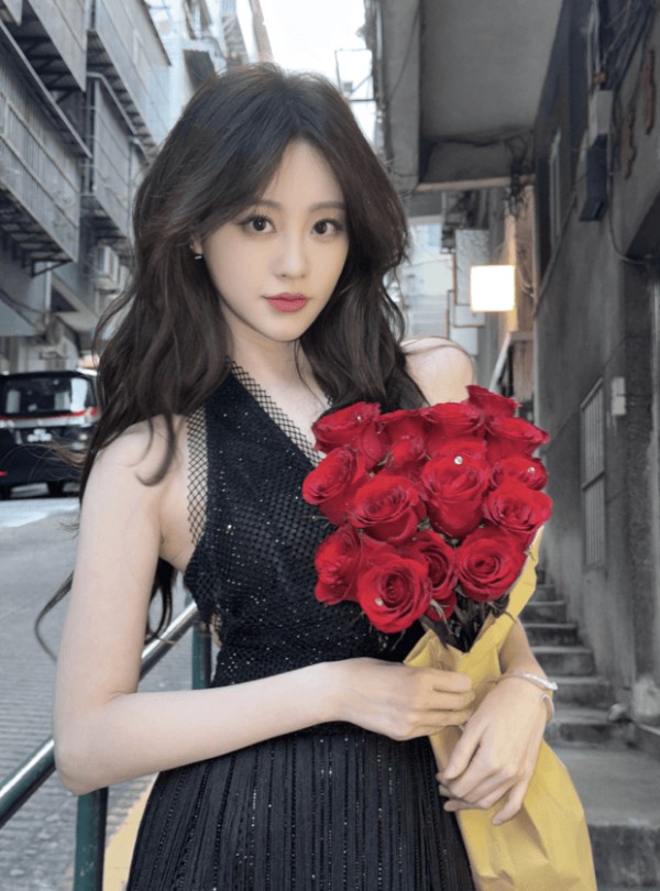 祝绪丹怀捧红玫瑰,抬眸的神态里裹着温柔又灵动的气息。