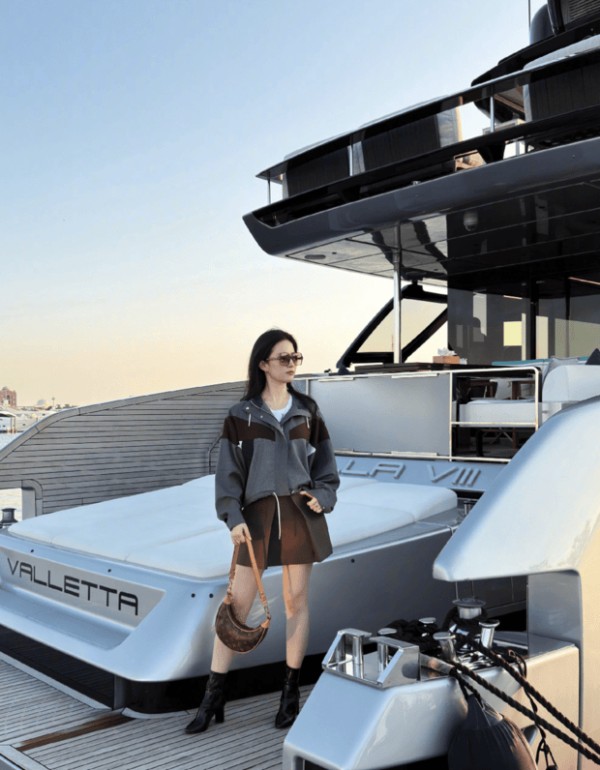 刘亦菲戴着墨镜在船头摆姿势拍照。