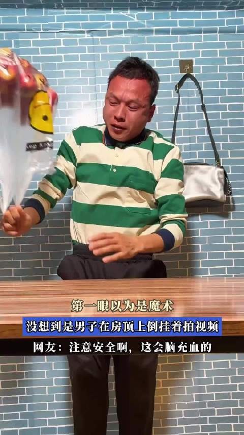 第一眼以为是魔术,没想到是男子在房顶上倒挂着拍视频