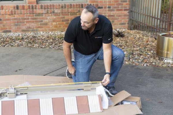 Person measuring fabric width for a home awning installation