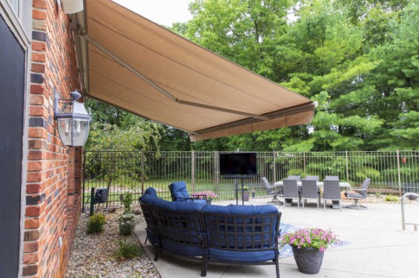 Residential awning installed on a brick home