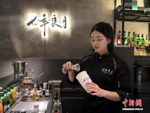 图为七年良月奶茶店店员在制作罗汉果奶茶。李霞 摄