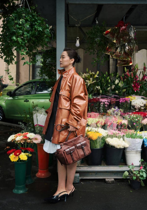 贾玲现身花摊前，棕皮衣造型超有氛围感。