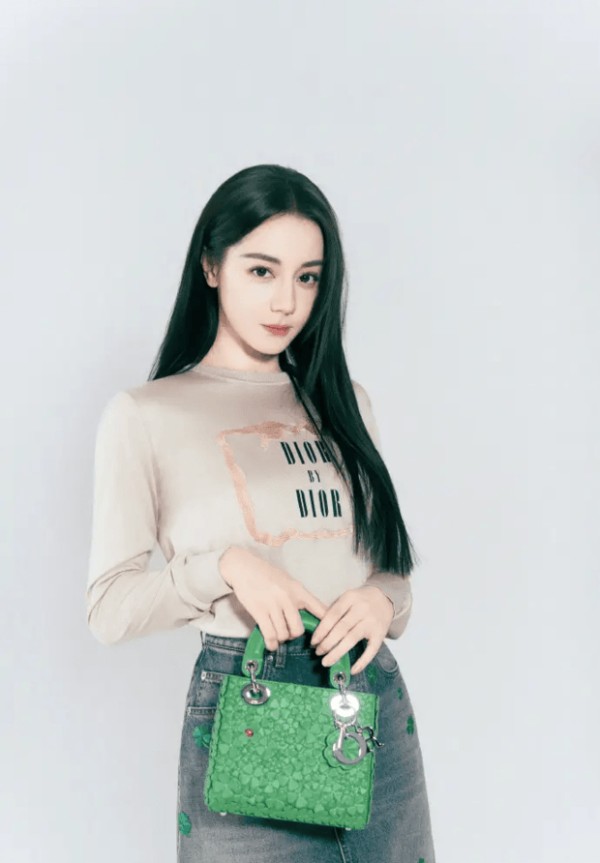 迪丽热巴双手握包，造型精致时尚。