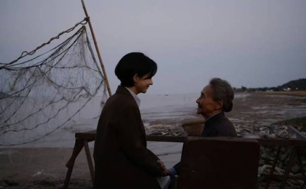 二人相视而笑,祖孙情谊在海边流淌。