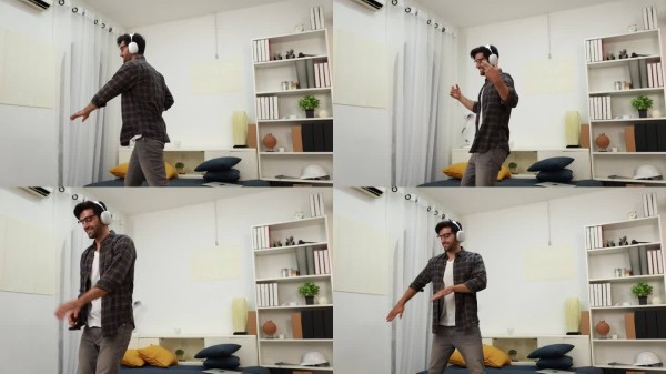 年轻男子在家中阁楼的室内享受舞蹈乐趣。帅气的年轻人在家跳舞。