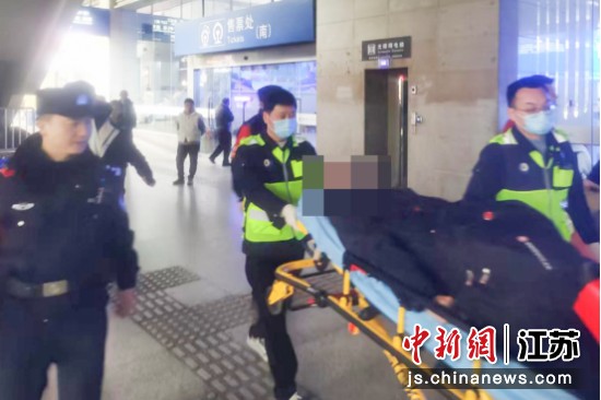 民警护送突发疾病的旅客前往救护车。南京铁路公安处南京站派出所 供图