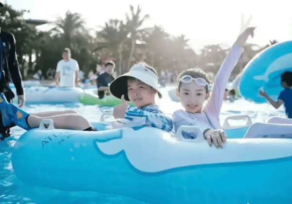 小酒窝和朵朵坐充气艇，笑容灿烂。