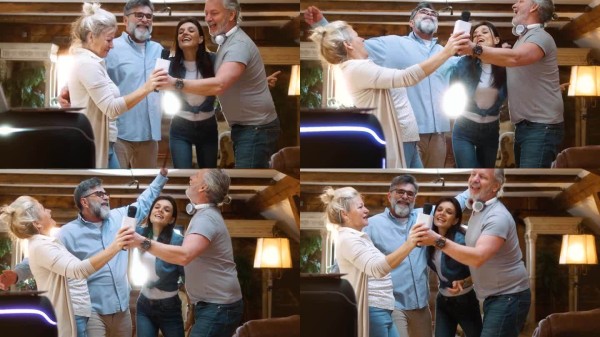 快乐的退休老年人团体在家中唱卡拉OK和跳舞,享受乐趣。