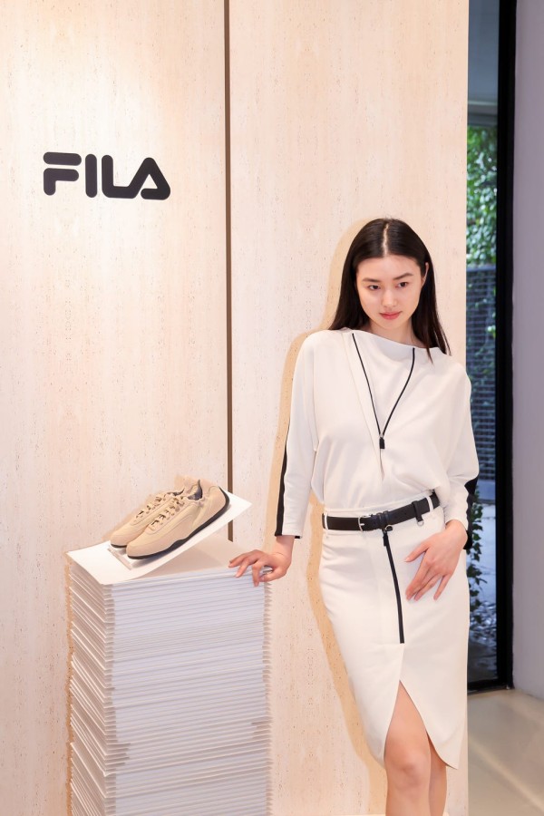 fashion display featuring a model beside sneakers in a store