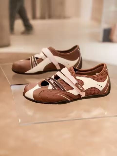 sporty brown and white shoes displayed on a glass surface