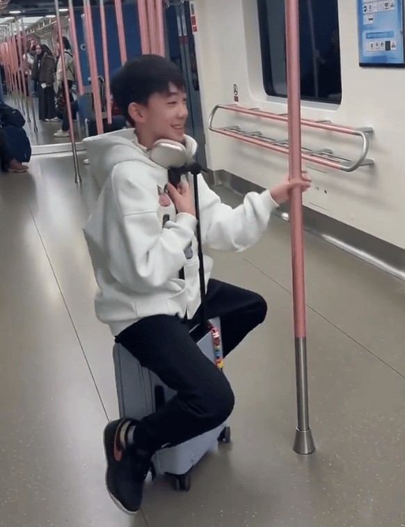 Jasper坐在行李箱上玩耍。