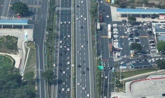 5月1日，深岑高速新城服务区路段，交警（道路左侧）带道通行的航拍画面。新华社发