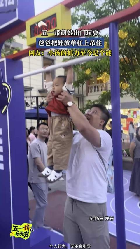五一带萌娃出门玩耍，爸爸把娃放单杠上吊住，网友：小孩的抓力至今是个谜！