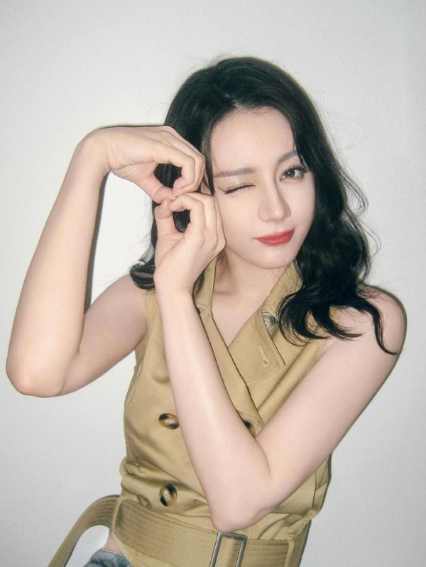 迪丽热巴wink甜笑，对着镜头比出“8”的手势。